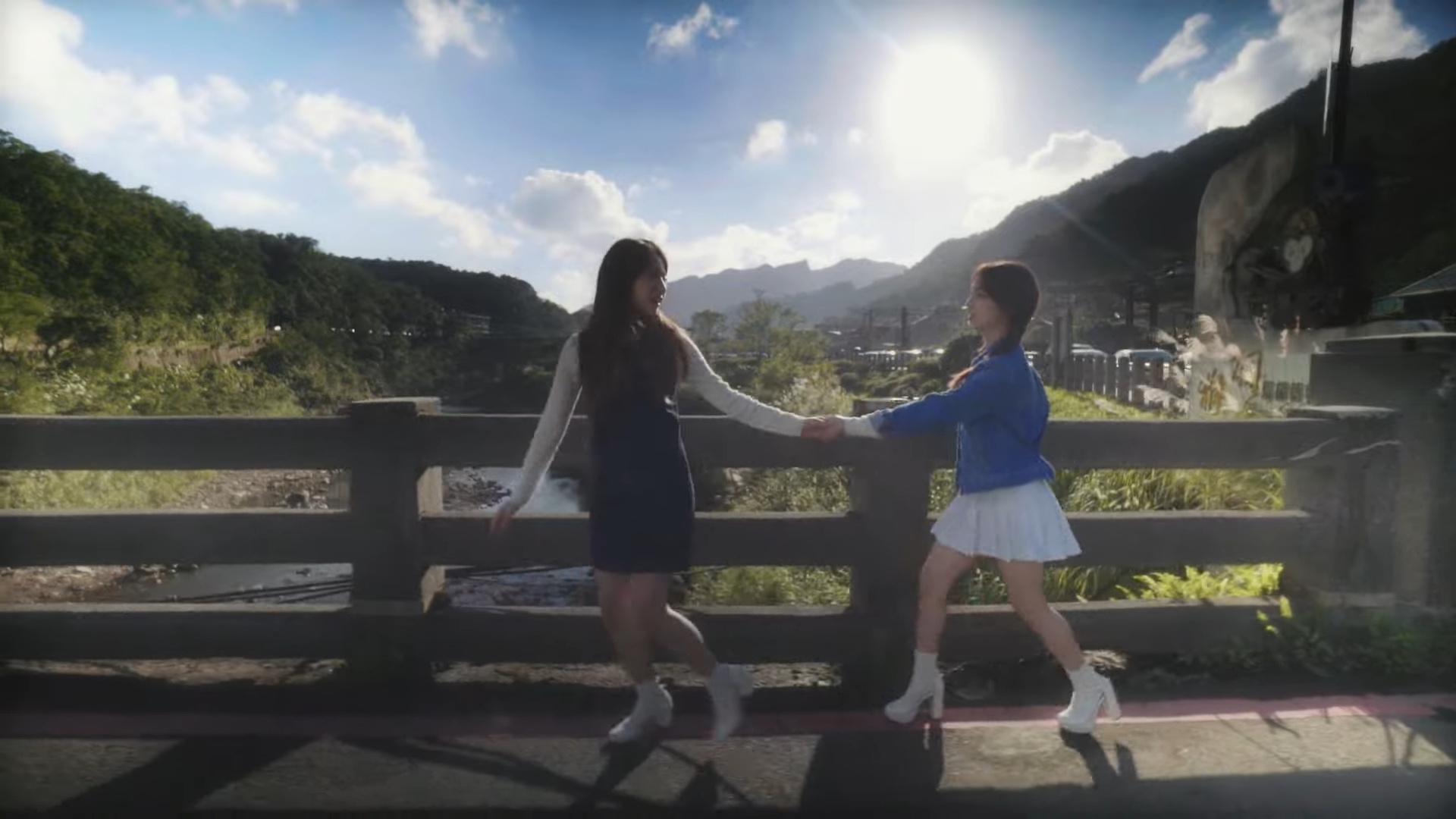 Haseul and Yeojin walking and holding hands.